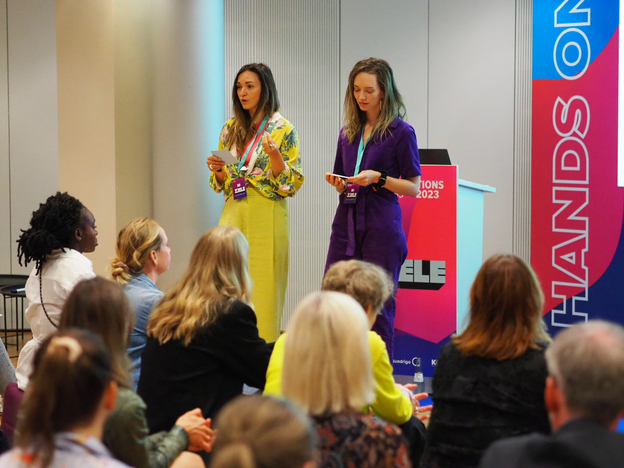 Sophie and Angelique presenting to a full room