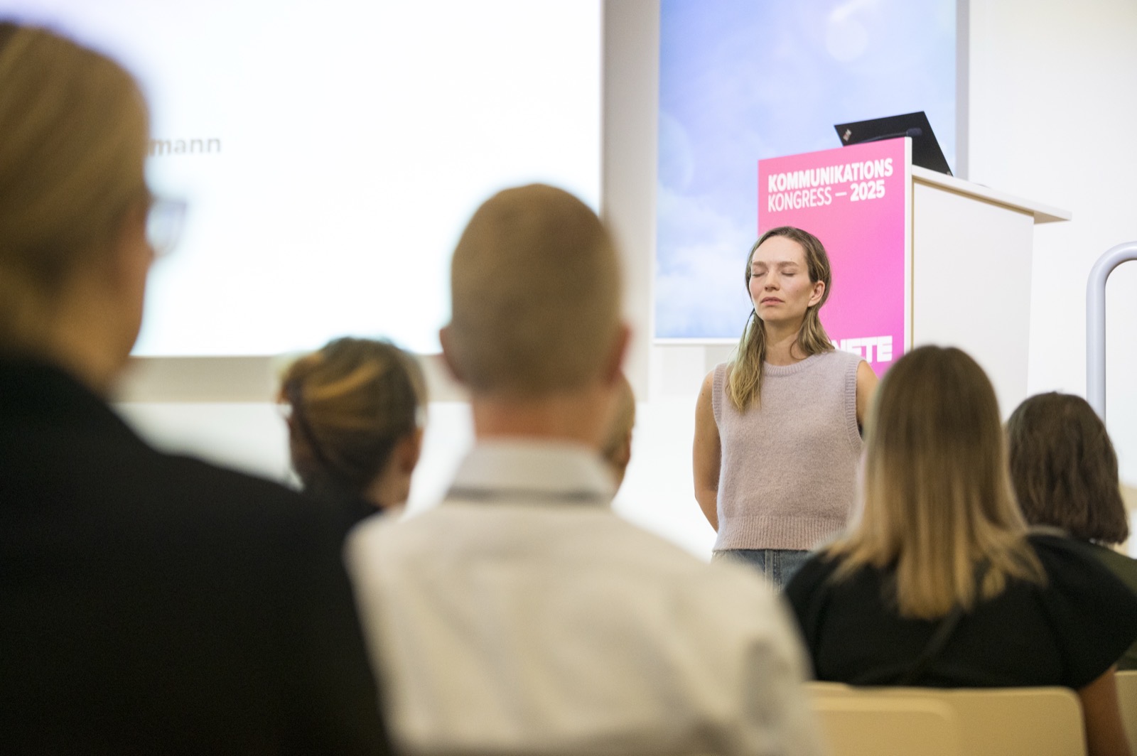 Sophie guiding a meditation on stage in front of a conference audience